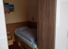 Blick auf ein Bett und einen Kleiderschrank